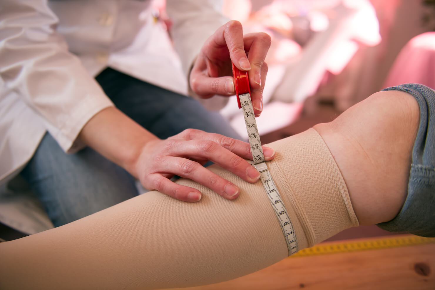 Doctor measuring compression stockings for vein insufficiency treatment