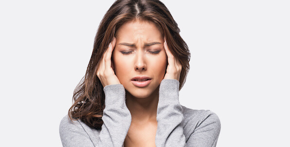 woman holding temples for migraine headache pain