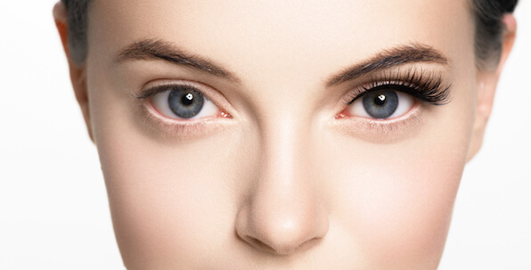 woman's face with thin lashes on one eye and thick full lashes on the other eye