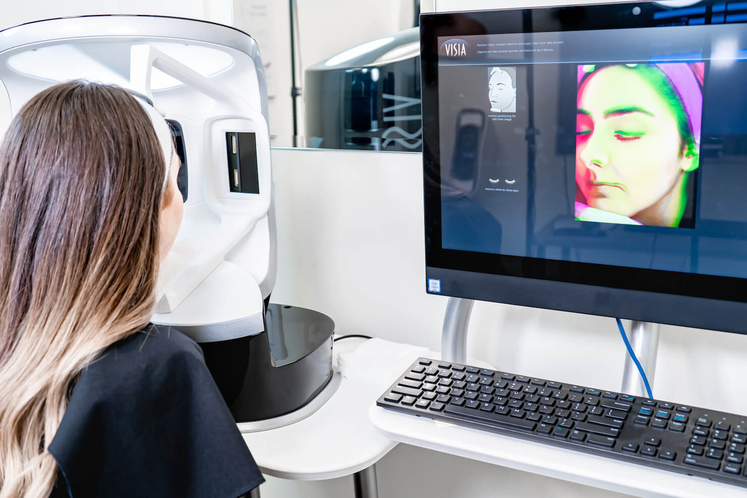 visia complexion analysis camera with patient ready for facial scan with uv photograph