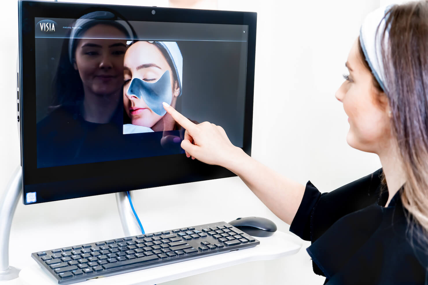 patient pointing at facial scan with visia camera showing facial curves structure graph